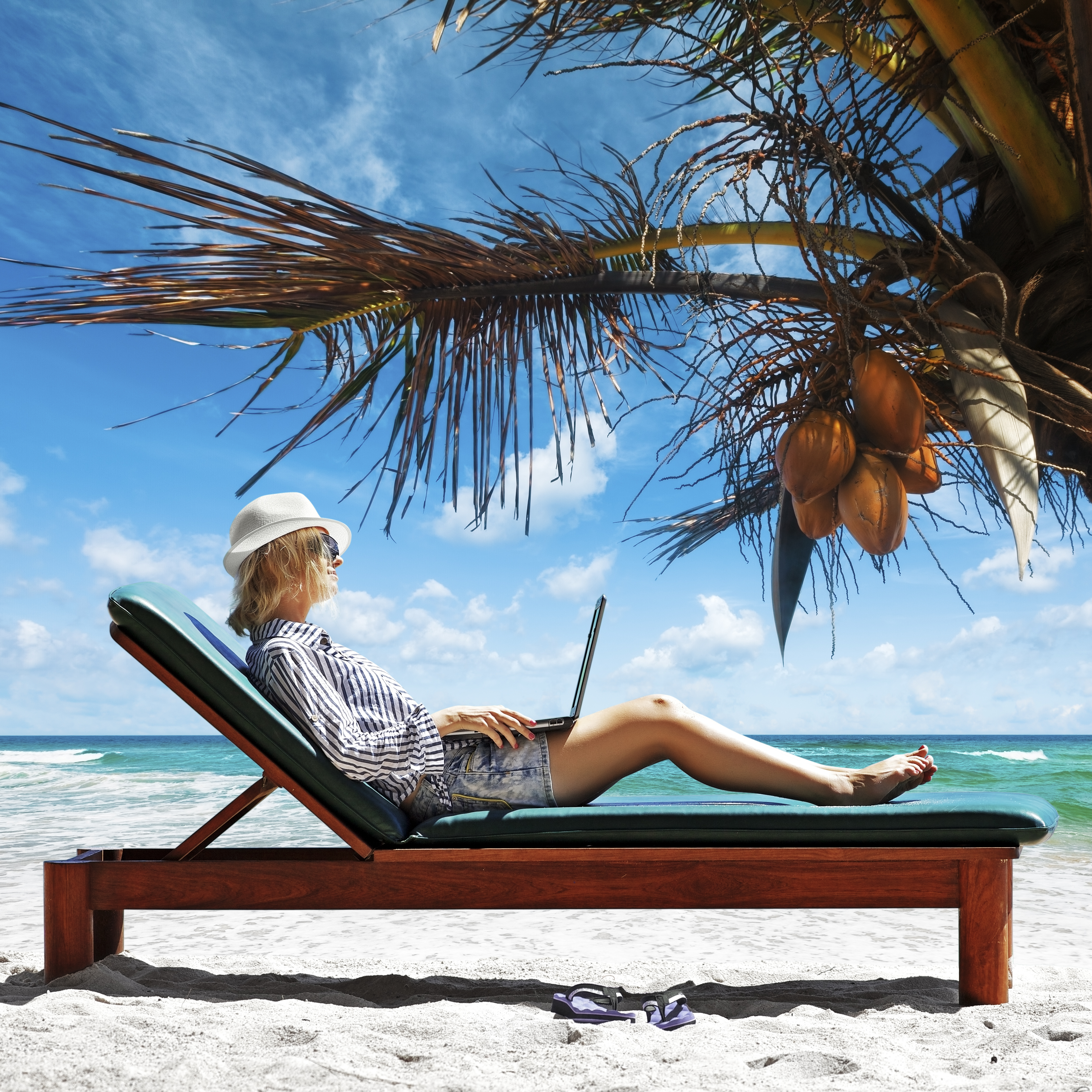 Young woman with laptop at the beach