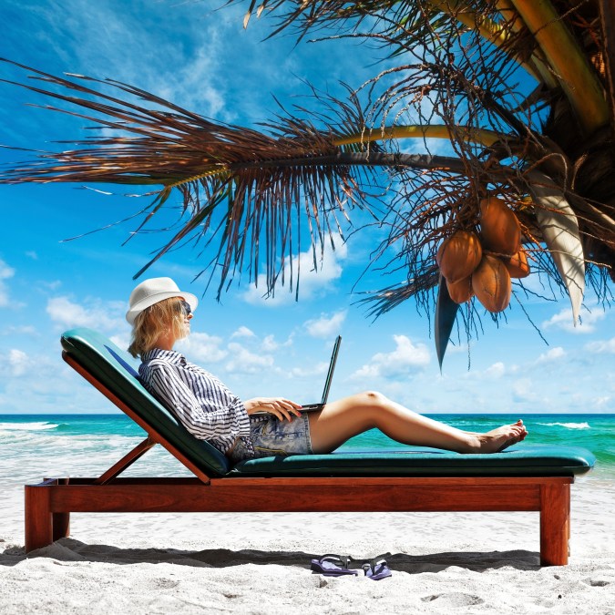 Young woman with laptop at the beach